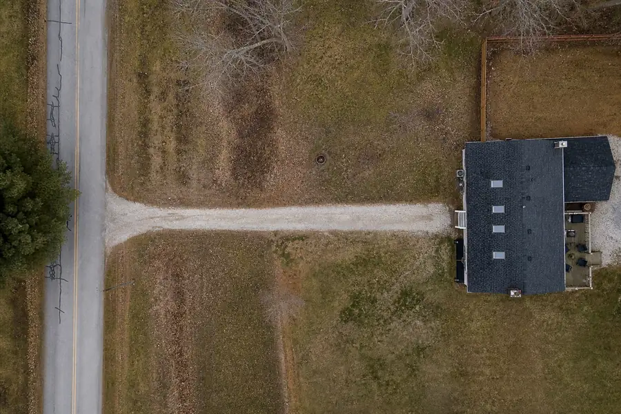A 100 foot gravel driveway between a road and a house
